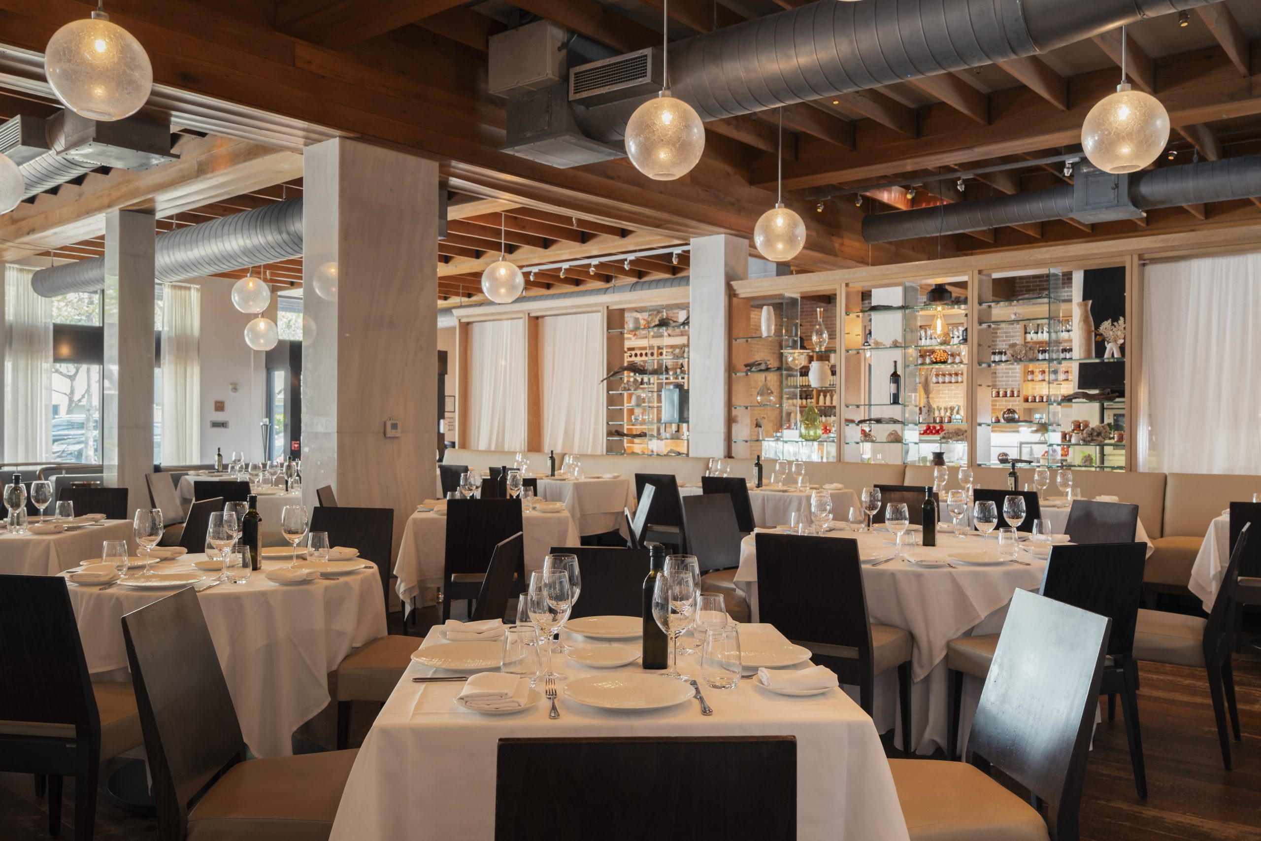 milos miami beach dining room with warm and comfortable tables covered in white table cloths